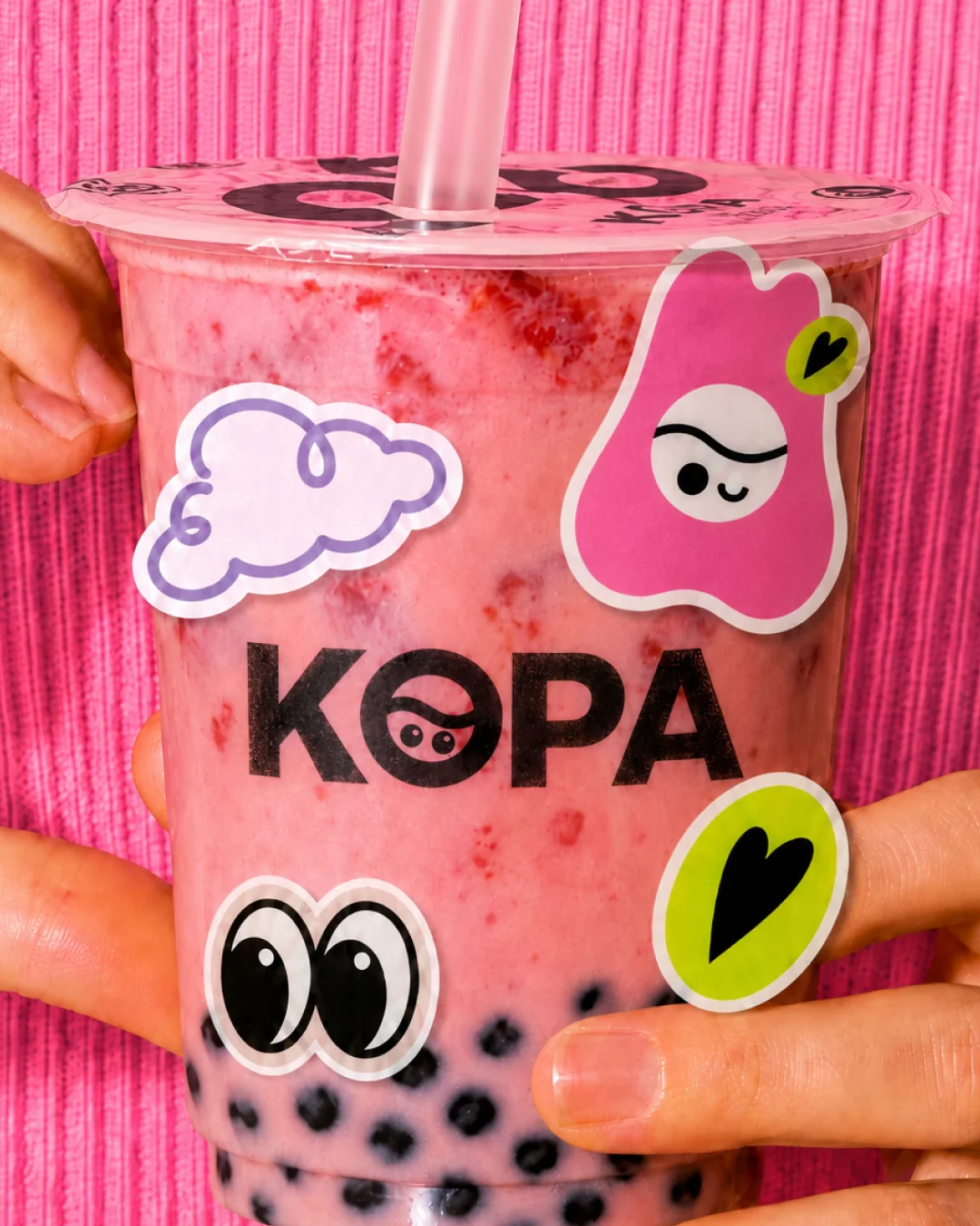 Pink KopaTea drink decorated with playful stickers